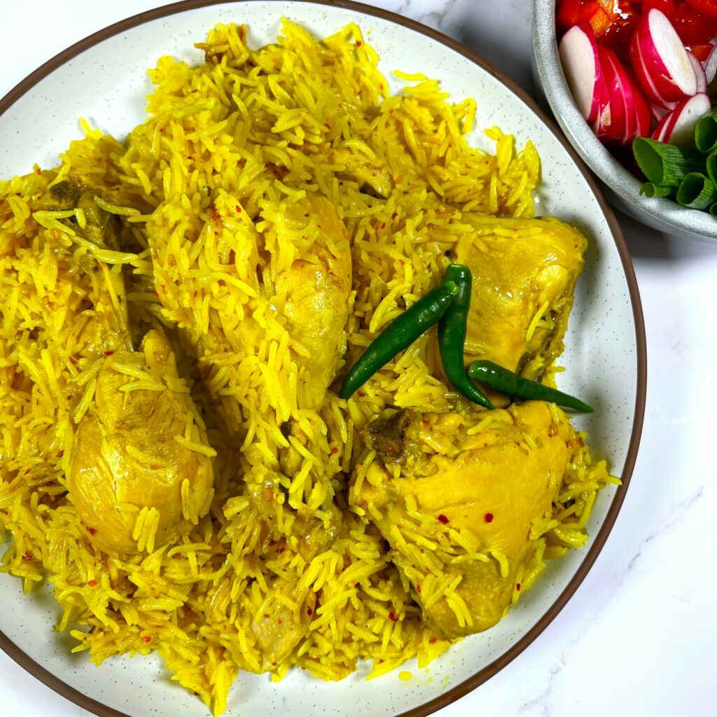 Afbeelding van Yakhni Pulao, een traditioneel Afghaans gerecht met perfect gekruide kip en geurige rijst, geserveerd met salata en groene pepers.
